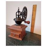 Antique-style tabletop flywheel coffee grinder.