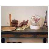 This vignette features a classic collection of vintage game bird decor, layered with traditional European style accents. Gold-trimmed white ceramic pastry tier. Carved lion head wall plaque.  Holland 
