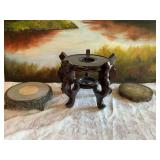 Three brass, metal and wood plant/jar stands. The metal four legged stand is 9” x 2”. The brass stand is 6 1/2” x 1”, the wood stand is 8” x 12”.