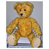 Research indicates this is a vintage mohair teddy bear, possibly from the 1920s to 1950s, featuring articulated joints. Has a "handle" at the bottom of the back that swivels the teddy bear