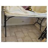 folding poly table with table cover. 60x27 x 29 in tall. Contents on table are not included.