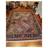 Area rug with colors of blue, turquoise, oatmeal, and burgundy. Backing is loose on corner area as shown. Includes pad. 93x122 in