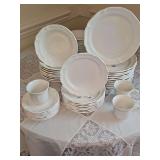 Mikasa French countryside dishes. Includes ate 10 dinner plates, eight salad plates, nine soup bowls, seven saucers, and three mugs. Includes three dish storage bags.
