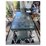 Green iron patio table with glass top 48x30x29 in tall. 4 iron chairs with stripe padded seat cushion 17x17x34 in tall. Seat height 19 in.