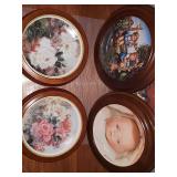 Four framed collector plates. MJ Hummel "Apple Tree Boy And Girl", The Doll Collection limited edition baby doll "ByeLo" by Mildred Seeley and two framed floral plates