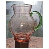 Two-tone pink and green "watermelon" glass pitcher, featuring an optic-ribbed or paneled pink body with an applied contrasting green handle.
