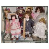 Grouping of porcelain dolls on stands.