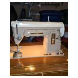 Vintage beige and cream Singer Model 404 slant-needle sewing machine from the late 1950s in cabinet. 23.75 x 16 x 31 in tall. This model machine is known for its durable all-metal gear-driven straight