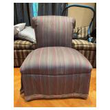 Classic armless slipper chair upholstered in a multicolored vertical stripe fabric with a traditional skirted base
