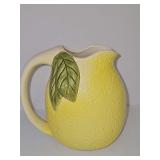 Lemon pouring pitcher. 6.5 in tall. Glaze was missed on a portion of the interior as shown. Manufacturer defect.