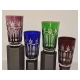 Purple, blue, green, and  ruby red cut-to-clear crystal highball glass with vertical fluting and a delicate leaf motif along the rim. 6 in tall.