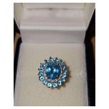 10K yellow gold ring with large light blue stone surrounded by clear chip stones and light blue stones. Size 7 weighing 4.8 g