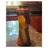 Vintage American art pottery vase featuring a standard brown-to-amber gloss glaze decorated with hand-painted yellow and orange florals - 11” tall
