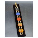 Vintage gold-tone multi-gemstone scarab link bracelet featuring intricately carved colorful stones