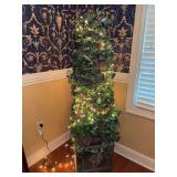 Artificial spiral ivy topiary tree wrapped in warm white fairy lights