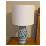 Light blue ceramic table lamp featuring an open lattice pineapple cutout pattern and a classic white drum shade - 22-1/2 tall