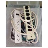 Clear plastic storage box with 2 surge protectors and extension cords