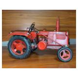 Rustic red vintage-style metal tractor model with black rubber tires and a steering wheel - 9-1/2 long x 6-1/2 tall