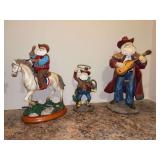 Grouping of (3) resin Western themed Santa’s - 8”, 11-1/2” and 13” tall - far left is missing something he holds in his hand