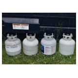 Four 20lb LP gas grill tanks with safety valves; a