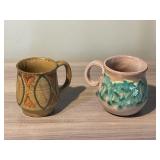 (2) POTTERY MUGS WITH HANDLES AND DESIGN