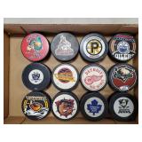 (12) Assorted Team Hockey Pucks
