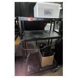 black metal rolling cart and box of keyboards