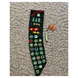 Girl Scout sash with patches and pins