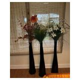 Trio of tall glass vases with floral arrangements