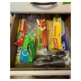 Contents of lower kitchen cupboards includes storage containers, plastic wear, flatware, steak knives, kitchen wraps, cleaning brushes, pots and pans, cake pans, cookie sheets, pressure cooker and mor