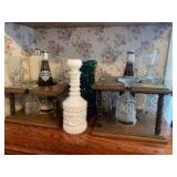 Wine decanters and wine glasses in racks along with two bottles of Blue Nun, one is dated 1978