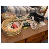 Variety of ladies costume jewelry includes clip on earrings of all kinds, lots of beads and necklaces, brooches, etc all bundled up in a sewing basket