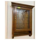Quarter sawn oak wall display cabinet with leaded glass door Measures 7in deep x 28in wide x 38in tall Glass shelves inside are 3.5in wide