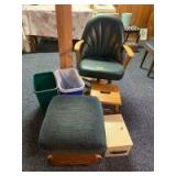 Kitchen arm chair that swivels and is on casters, a glider footstool, second small step stool with handle in the center, two plastic waste baskets and a metal lock box