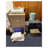 Two door legal size file cabinet, Smith Corona electric typewriter, variety of office supplies, metal lock box, zebra pattern chair with the back cut off and waste baskets