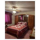 Queen bed w/ storage cabinets on each side and mirrored back Linens included as well as quilt smapler on wall!