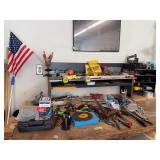 Workbench contents includes saws, allen wrenches, staple gun, drill press vise,  tape measures and more