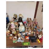All kinds of ceramics on top of table includes clowns, bears, dogs, etc