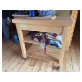 Rolling kitchen island with single drawer and assorted table linens