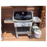 Weber charcoal grill Spirit 2 with two propane tanks, one nearly full and one empty