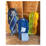 Three snow sleds, including one ice sledding on grass sled