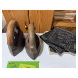 2 sad irons and 3 Dubuque Iowa cast iron plaques