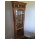 Lighted Corner Curio Cabinet features beveled glass side panels and multi-tier glass shelving, 28x16x73