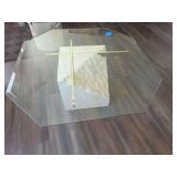 Coffee Table, featuring a stone or travertine pedestal base, intersecting brass support bars, and an octagonal glass top. 38x38x16