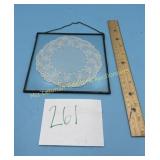 Decorate doily incased in a glass hanging piece