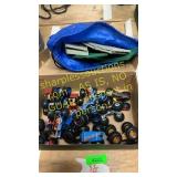 Box of Monster Trucks and bag plastic toy barn