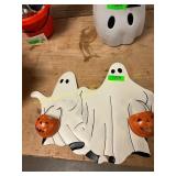 Two ghost sings holding pumpkins