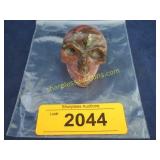 Carved red stone skeleton of head.