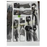 Assorted flatware in tray