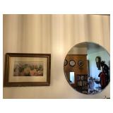 Round beveled mirror and floral picture